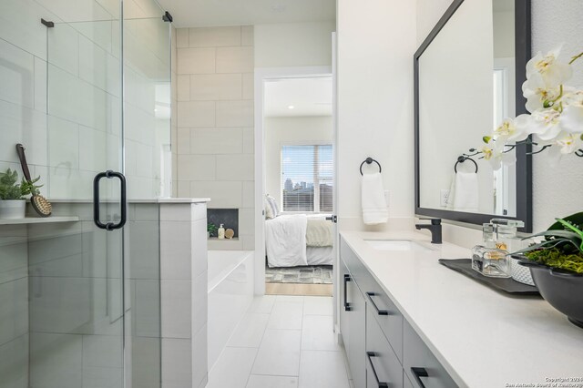 bathroom with shower with separate bathtub, vanity, and tile patterned floors