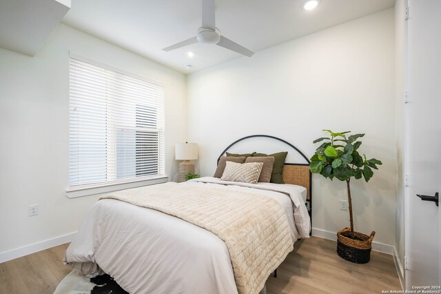 bedroom with ceiling fan and light hardwood / wood-style floors