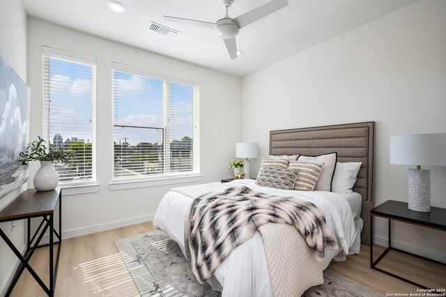 bedroom with light hardwood / wood-style flooring, multiple windows, and ceiling fan