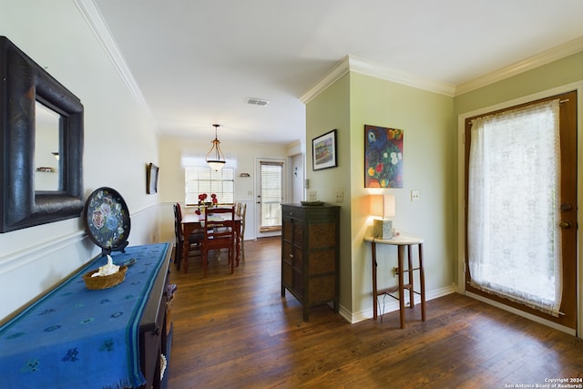 interior space featuring visible vents, baseboards, dark wood finished floors, and crown molding