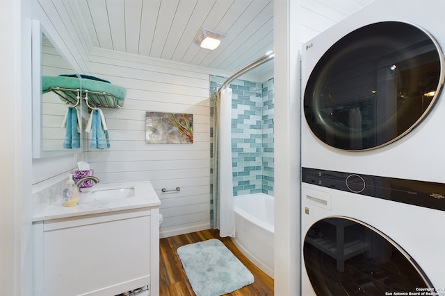 bathroom featuring shower / bath combo with shower curtain, wood finished floors, stacked washing maching and dryer, wood ceiling, and vanity