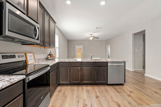 kitchen featuring ceiling fan, dark brown cabinets, light hardwood / wood-style floors, kitchen peninsula, and stainless steel appliances