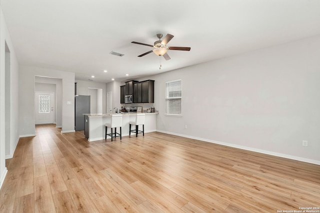 unfurnished living room featuring ceiling fan and light wood-type flooring