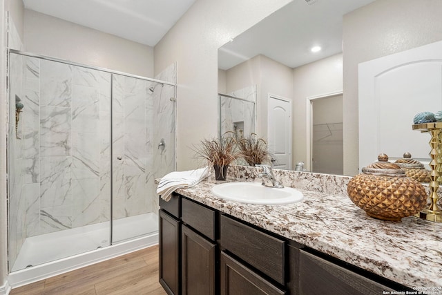 bathroom featuring hardwood / wood-style floors, vanity, and an enclosed shower