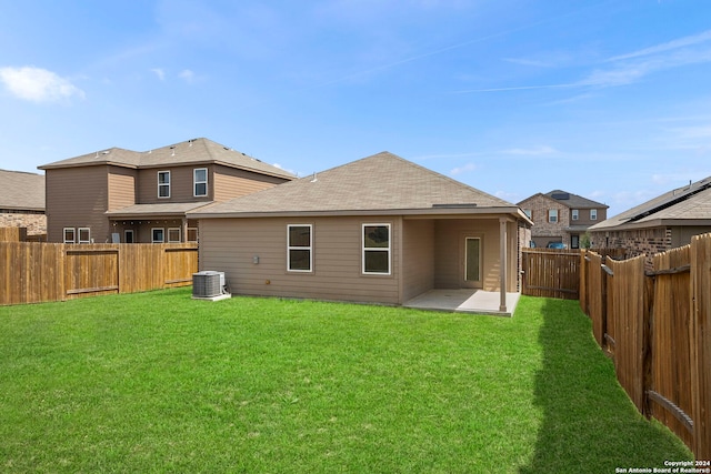 rear view of property featuring a lawn, central AC, and a patio