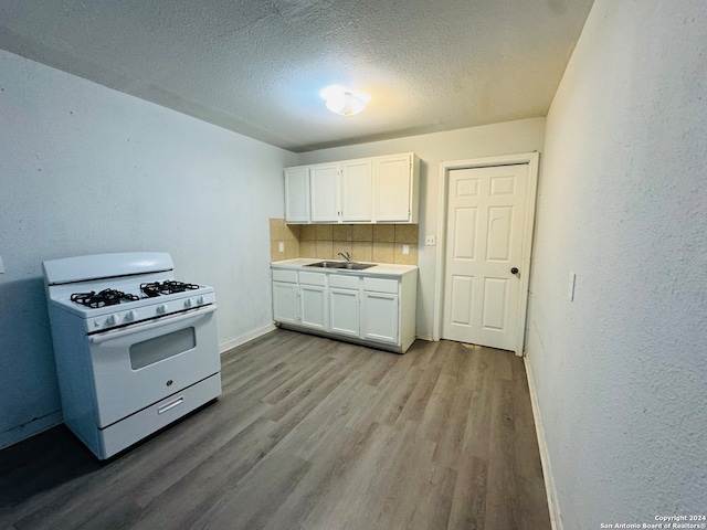 kitchen featuring white cabinetry, white gas range, hardwood / wood-style floors, sink, and tasteful backsplash