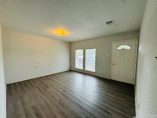 entryway with a textured ceiling and dark hardwood / wood-style floors