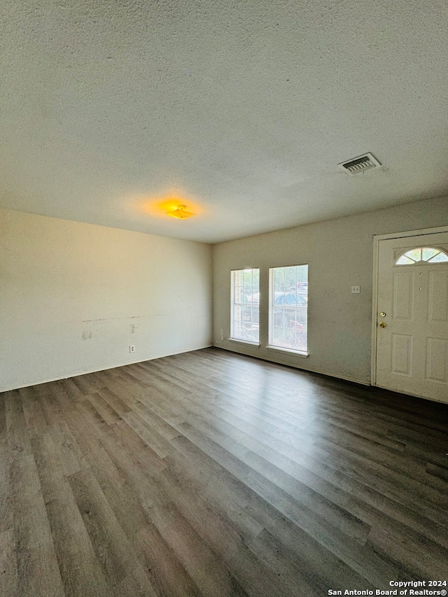 unfurnished room featuring a textured ceiling and dark wood-type flooring