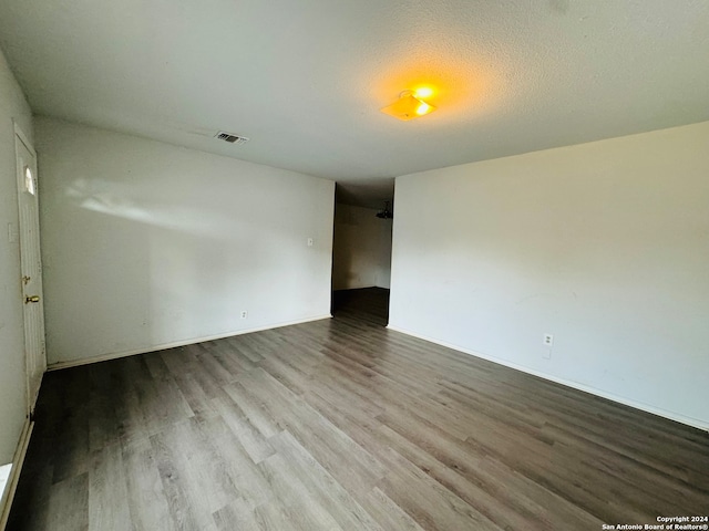 spare room featuring wood-type flooring