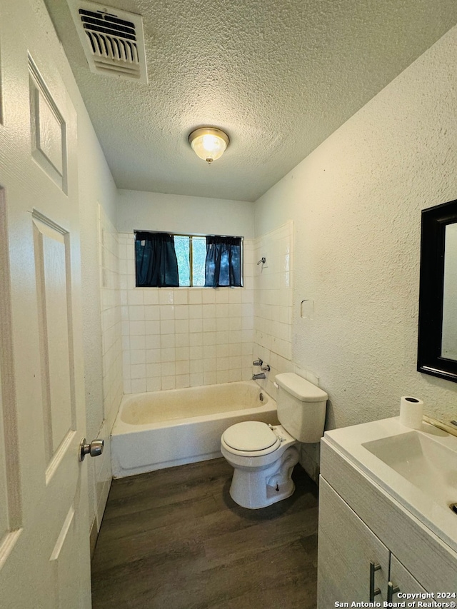 full bathroom featuring hardwood / wood-style flooring, toilet, vanity, and tiled shower / bath