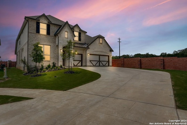 french provincial home with a yard and a garage