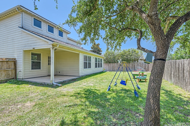 back of house with a yard, a playground, and a patio area