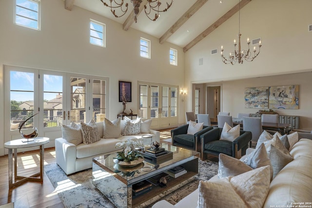 living room featuring french doors, wood-type flooring, a notable chandelier, a towering ceiling, and beam ceiling