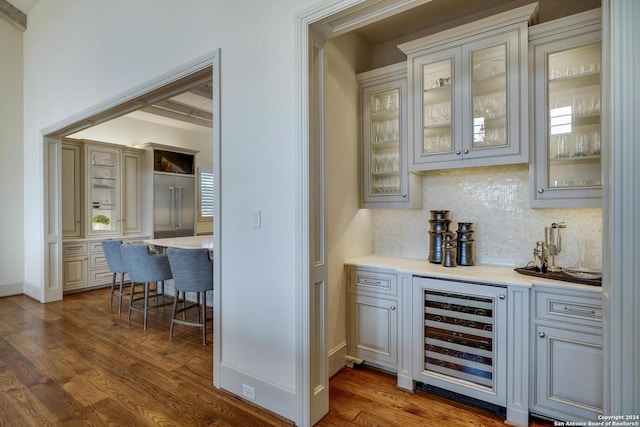 bar featuring wine cooler, decorative backsplash, and dark hardwood / wood-style floors