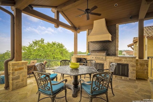 view of patio / terrace featuring ceiling fan, a grill, a fireplace, and exterior kitchen