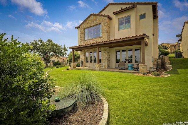 rear view of property with a yard, a patio, and central air condition unit