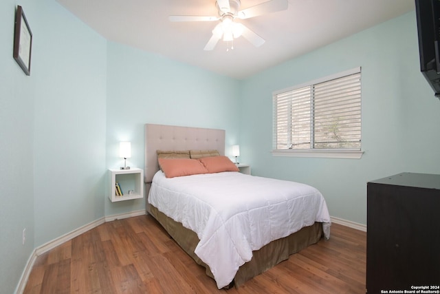 bedroom with a ceiling fan, baseboards, and wood finished floors