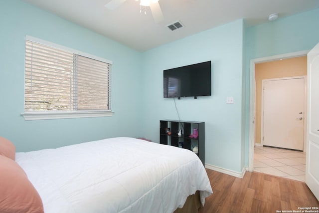 bedroom with visible vents, ceiling fan, baseboards, and wood finished floors