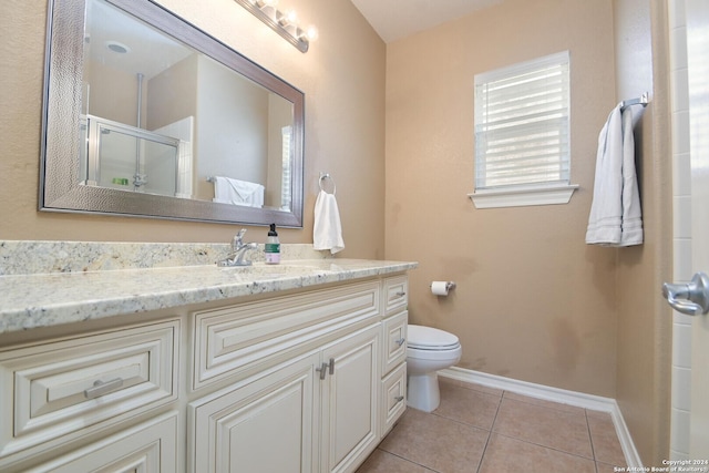 full bath featuring tile patterned flooring, toilet, vanity, baseboards, and a shower stall