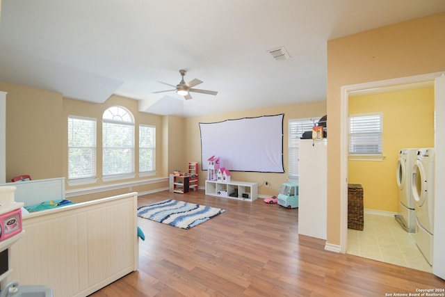 interior space featuring separate washer and dryer, hardwood / wood-style flooring, and ceiling fan