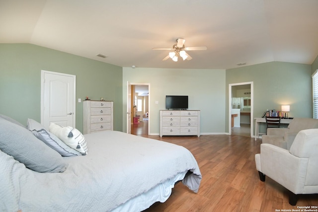 bedroom with ceiling fan, hardwood / wood-style floors, and vaulted ceiling