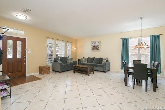 interior space with light tile patterned floors, an inviting chandelier, visible vents, and a healthy amount of sunlight