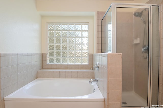 bathroom with a shower stall and a bath