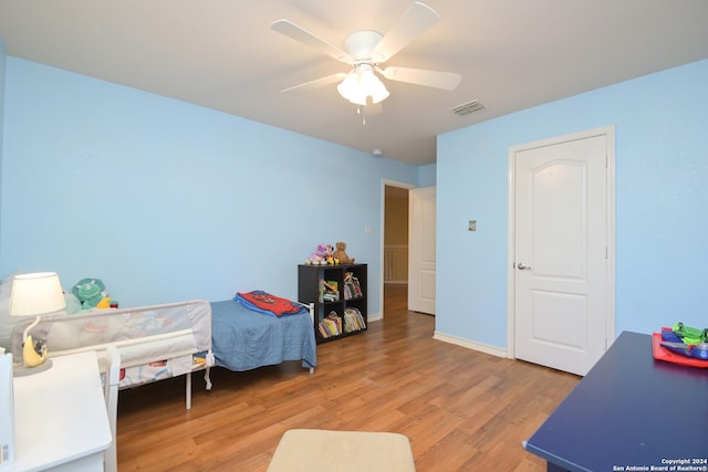 bedroom with light wood-type flooring, visible vents, ceiling fan, and baseboards