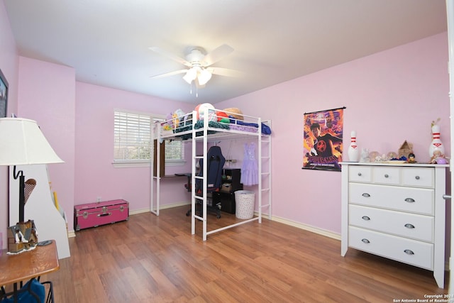 bedroom with light wood-type flooring, a ceiling fan, and baseboards