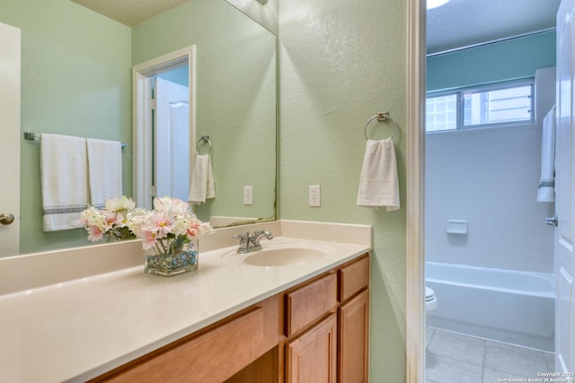 full bath featuring tile patterned flooring, a textured wall, vanity, and toilet