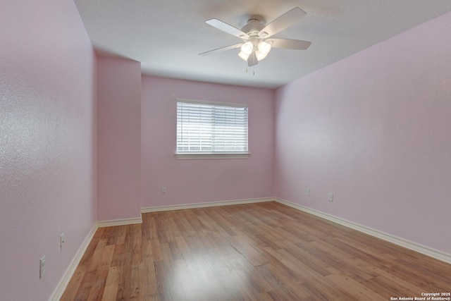 spare room featuring ceiling fan, baseboards, and wood finished floors