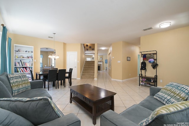 tiled living room featuring built in features and an inviting chandelier