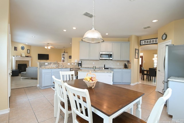 dining area with visible vents, a fireplace, and light tile patterned floors