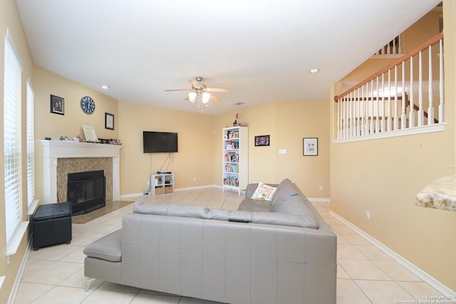 living room with ceiling fan, a fireplace, and light tile patterned floors