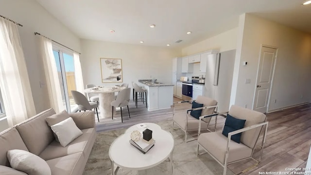 living room with plenty of natural light and light hardwood / wood-style flooring