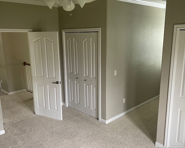 unfurnished bedroom featuring light colored carpet and crown molding