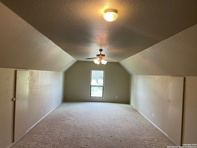 bonus room featuring a textured ceiling, light carpet, and vaulted ceiling