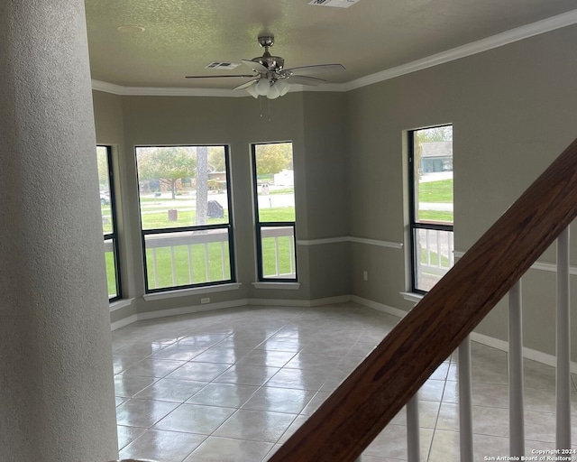 tiled spare room featuring a textured ceiling, ceiling fan, and crown molding