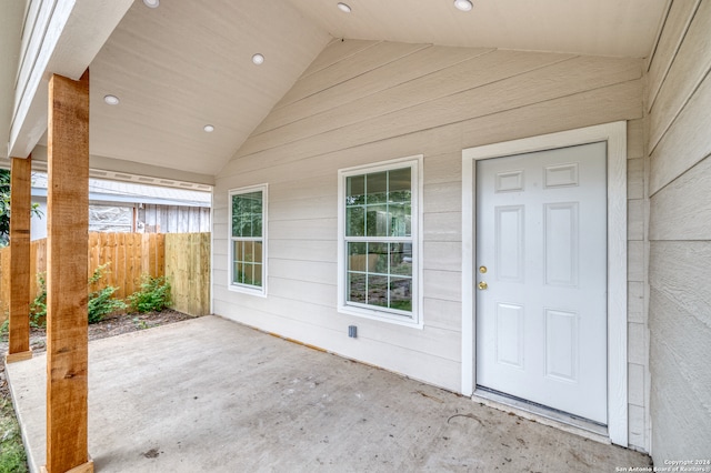 view of exterior entry with a patio area