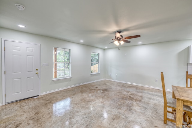 foyer entrance with ceiling fan and concrete floors