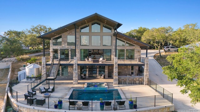 rear view of house with a fenced in pool, a bar, and a patio