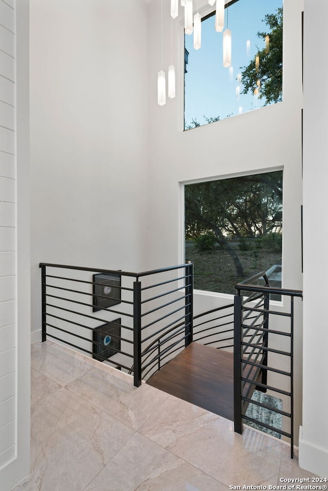 staircase featuring a towering ceiling and an inviting chandelier