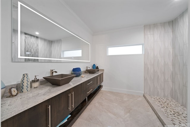 bathroom with tiled shower, vanity, and ornamental molding