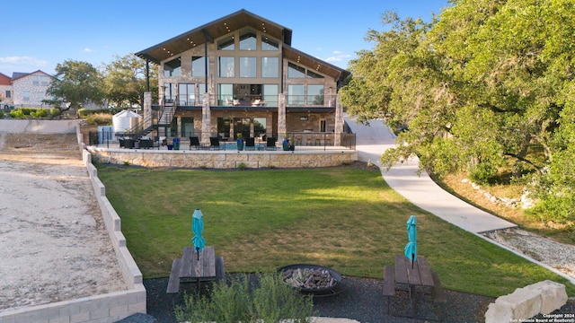 back of property featuring a patio area, a balcony, and a yard