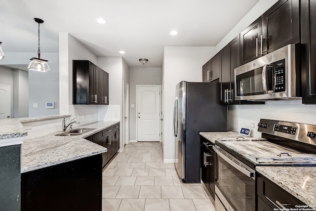 kitchen featuring decorative light fixtures, decorative backsplash, sink, appliances with stainless steel finishes, and light tile patterned floors