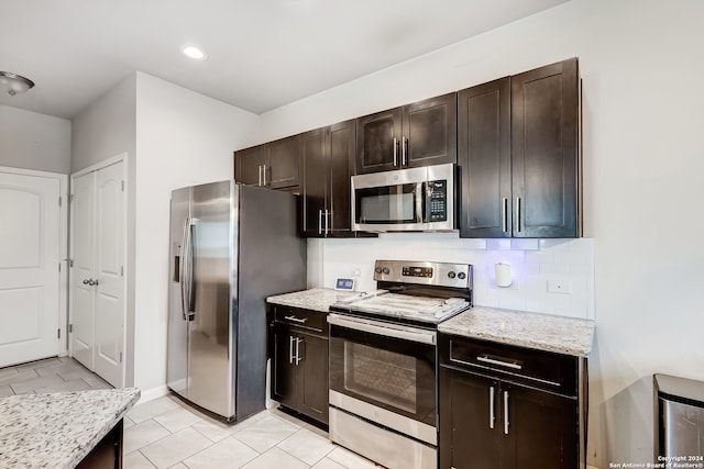 kitchen featuring dark brown cabinets, stainless steel appliances, backsplash, and light tile patterned floors