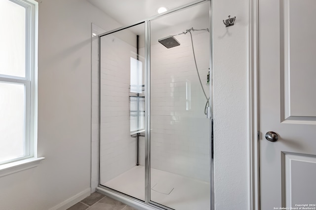 bathroom featuring a shower with shower door and tile patterned floors