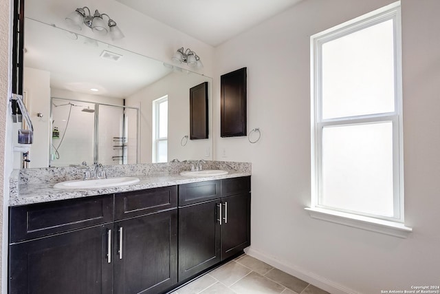 bathroom with vanity, a shower with shower door, and tile patterned flooring