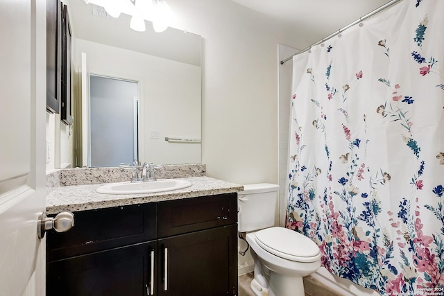 bathroom with walk in shower, vanity, and toilet