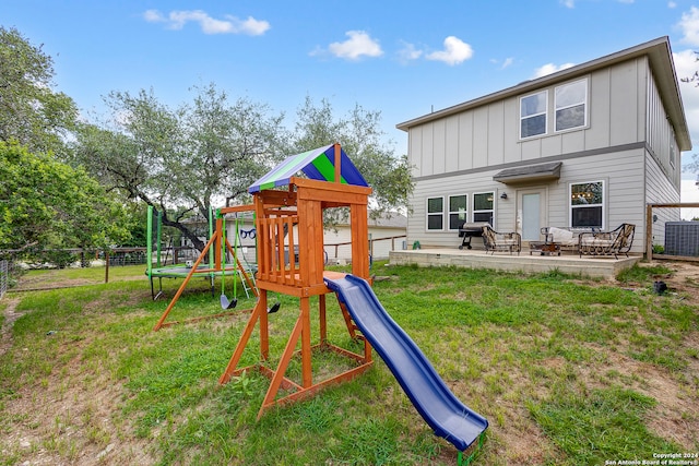 view of playground featuring a yard, a patio, and central air condition unit